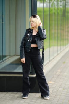 Young teenager model in black clothes and sunglasses outdoors