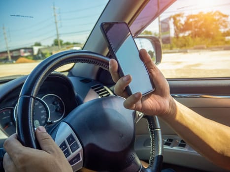 A man's hand held the steering wheel of a car to steer while the car was moving away. Concept and direction of business operations according to the plan. Direction control concept.
