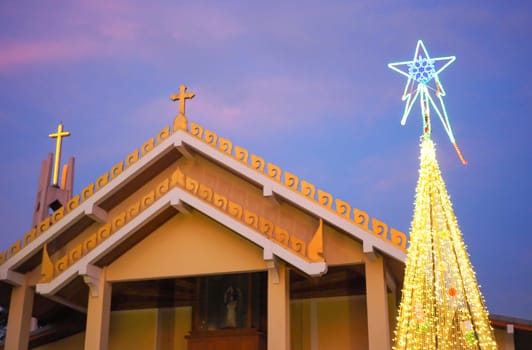 Catholic church with Christmas tree and lights at night