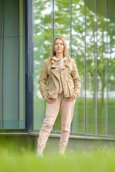 Sporty woman in track suit stands near the reinforced glass wall of her condo