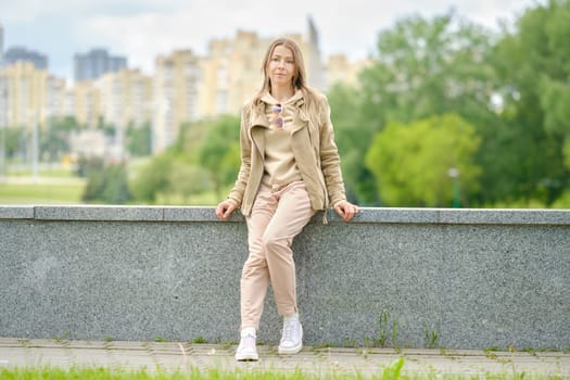Sportive middle aged woman sitting on an embankment