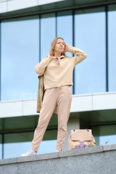 Sportive middle-aged woman looks into the distance while waiting for her friend