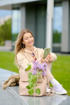 Middle aged woman dialing phone number outdoors