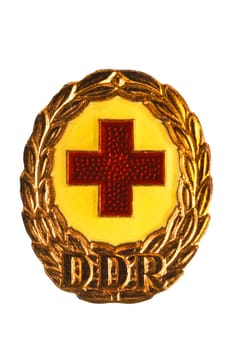Potsdam, Germany - DEC 12, 2022. Badges, orders and medals from GDR (DDR). Close-up of a National Defence Badge of the German Red Cross in bronze. Clipping path. Macro isolated on white.