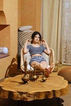 Careless young girl rest in wicker armchair Middle Eastern style room