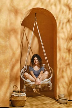 An image of a funny young girl in a swing in a harsh light