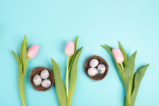 Easter eggs in a bird nest, pink tulips, holiday greeting card, spring season background
