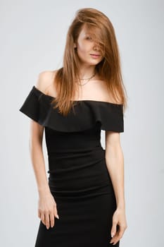 Studio portrait of pretty young woman in black dress