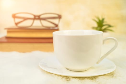 Coffee cup with book stacked on table,Coffee time in the morning