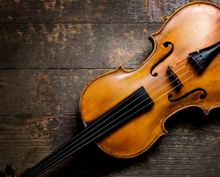 Violin on rustic wooden background from above. Classical musical string instrument. Classic music concept.