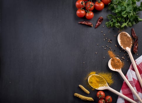 Food ingredients and various spices on black rustic background from above. Cooking and gastronomy concept.
