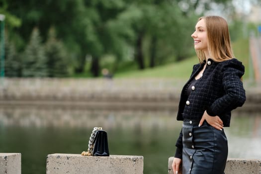 Young cheerful woman posing outdoor with a river on background