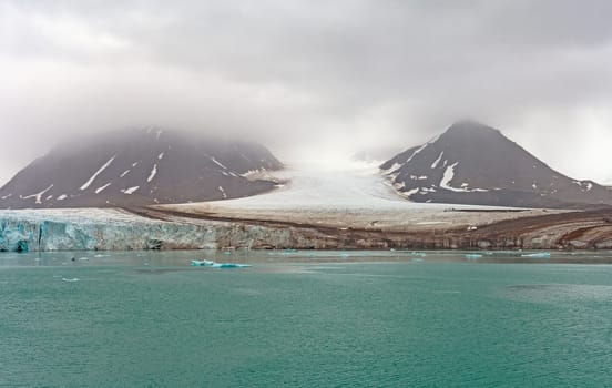 Tidal Glacier Coming Out of the Clouds at Lilliehookfjorden in the Svalbard Islands in Norway