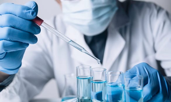 Researcher with glass laboratory chemical test tubes with liquid for analytical , medical, pharmaceutical and scientific research concept.