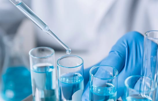 Researcher with glass laboratory chemical test tubes with liquid for analytical , medical, pharmaceutical and scientific research concept.