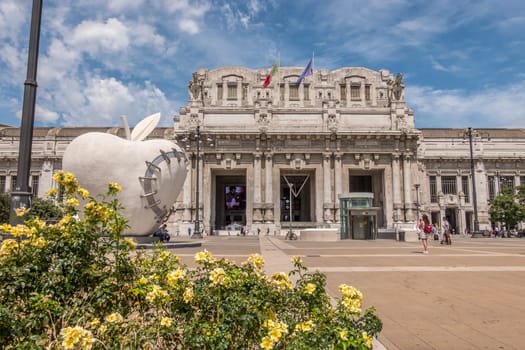 Milan, Italy - 06 23 2021: Square with flowers of the central railway station of the city of Milan in Italy.