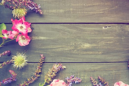 Flowers in a semicircle on a wooden background. Postcard for the holiday. Roses, lavender, sage and hairy chestnuts along the edges on dark boards. Background copy space flat lay. Retro vintage poster