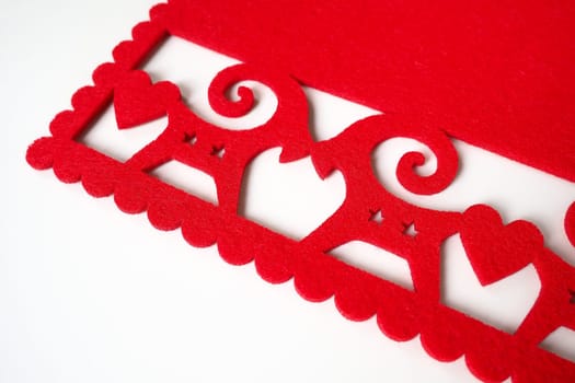 Background New Year's or for Valentine's Day. Kissing goats with stars and hearts are carved on red felt fabric. Merry Christmas and Happy New Year. Postcard, congratulation or invitation. Copy space