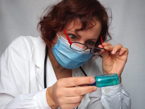 Doctor reading drug label of bottle medicine for give medicine to patient. Medical and Health Care. The doctor examines the medicine bottle and is very surprised. Reaction of surprise and indignation