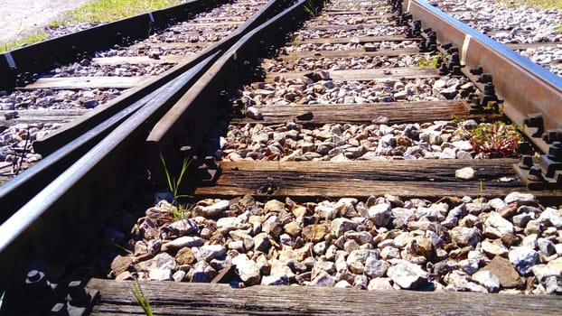Railway. rails and old wooden sleepers close up. Rocky ground. Retro style