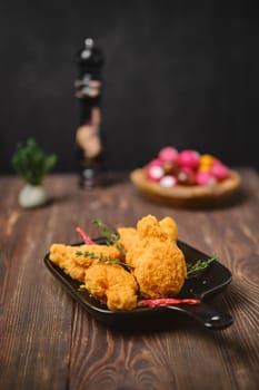Selective focus photo of deep fried breaded chicken wings on shabby serving board