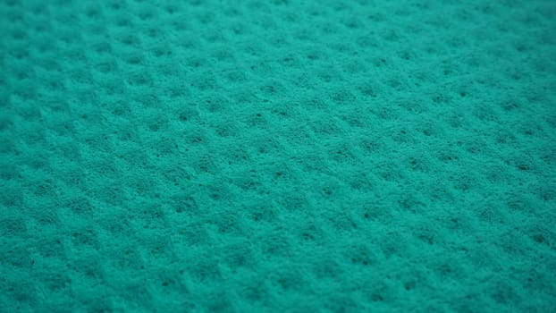 Sponge fibers sponge texture pattern surface close-up green background.