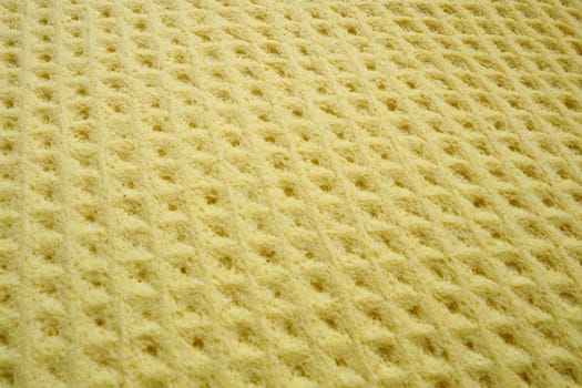 Sponge fibers sponge texture pattern surface close-up yellow background.