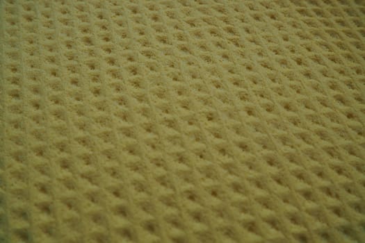 Sponge fibers sponge texture pattern surface close-up yellow brown background.