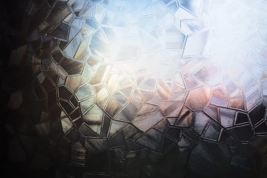 Fluted glass with backlight. Beautiful multicolored refraction of light. Abstract background. Self-adhesive film. Ribbed glass surface. Embossed glass background.