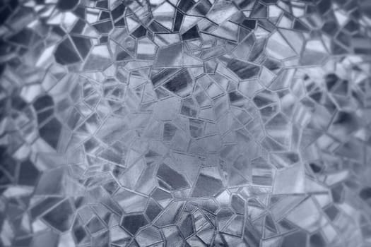 Embossed glass background. Corrugated glass monochrome. Refraction of light in a bumpy transparent surface under backlight. The play of white and gray highlights. Black areas. Abstract background