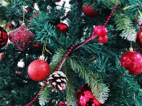 Christmas tree with decorations, Christmas balls and toys. Red and white hanging ornaments. Beautiful balls, bright berries and cones