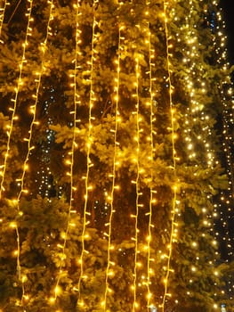 Festive garland. City night light blur bokeh, defocused background. Christmas bokeh. Beautiful lights against the black night sky. Street decoration for New Year and Christmas.