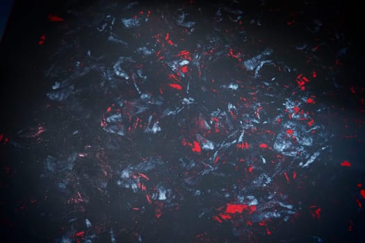 Black background with red, white, gray and blue strokes, dashes, stains and scuffs. A ray of light