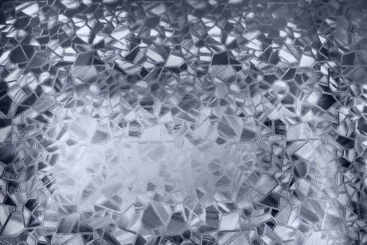 Embossed glass background. Corrugated glass monochrome. Refraction of light in a bumpy transparent surface under backlight. The play of white and gray highlights. Black areas. Abstract background