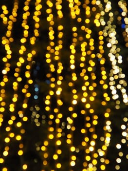 Festive garland. City night light blur bokeh, defocused background. Christmas bokeh. Beautiful lights against the black night sky. Street decoration for New Year and Christmas.