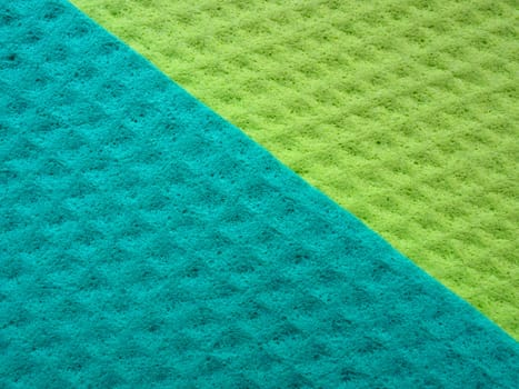 Sponge fibers sponge texture pattern surface close-up green yellow background.