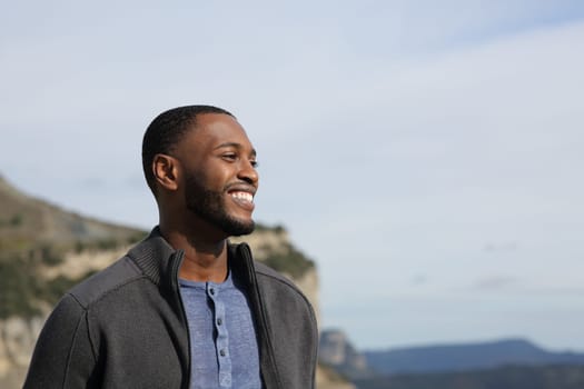 Happy black man contemplating views smiling in nature