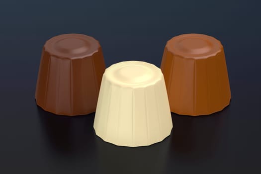 Milk, dark and white chocolate pralines on dark background