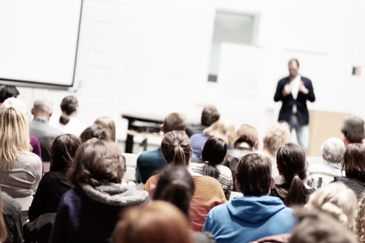 Speaker Giving a Talk at Business Meeting. Audience in the conference hall. Business and Entrepreneurship. Copy space on white board.