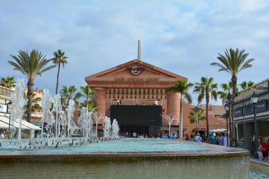 Centro Comercial Safari Shopping Mall, Playa de la Americas, Tenerife, Spain August 12, 2022 - Water fountain overlooking the Hard Rock Cafe with blue sky