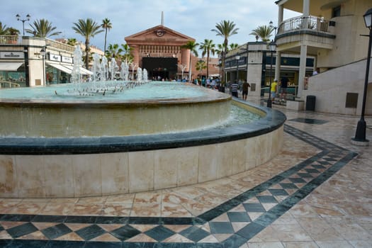 Centro Comercial Safari Shopping Mall, Playa de la Americas, Tenerife, Spain August 12, 2022 - Water fountain overlooking the Hard Rock Cafe with blue sky