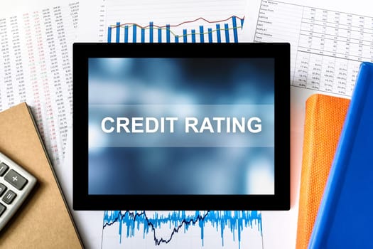 credit rating word on tablet with financial graph background