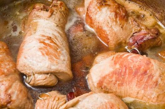 Close-up in a cooking pot of simmering poultry roulades