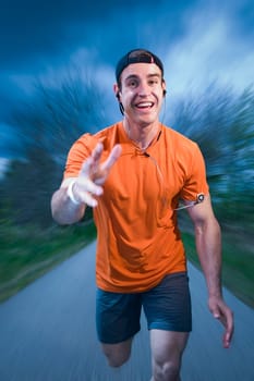 Frontal full-body view of a young man in an orange sports dress happily running towards the camera
