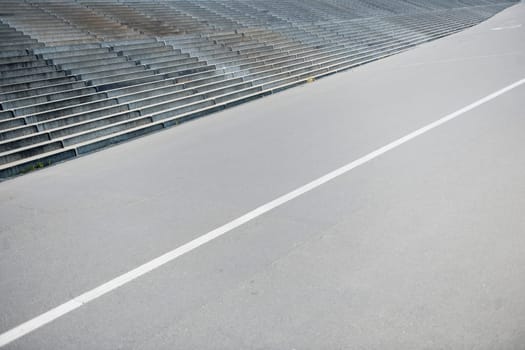 elevated diagonal view of a walkway with white dividing line and adjacent wide concrete staircase