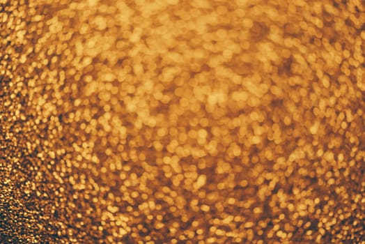 Golden glitter textured background for christmas and new year celebration party. Gold dust sparkling texture top view. Luxury and glamour bronze and brass pattern backdrop.