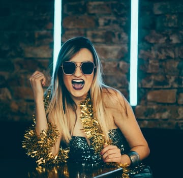 Young happy woman celebrating new year eve in night bar restaurant. Disco night lights and confetti. Lady clubber in nightclub having fun. Hipster girl at celebration luxury party.