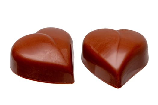 Fine milk chocolate chocolates in the shape of a heart isolated on a white background. Macro.