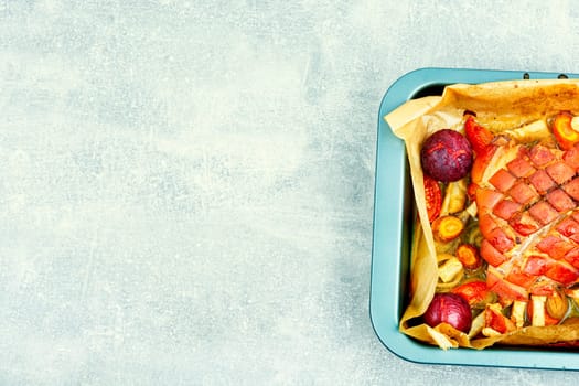 Juicy pork shoulder with skin and bacon cooked with vegetables and plums. Copy space