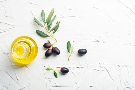 Olive oil bottle and olive branch on white background